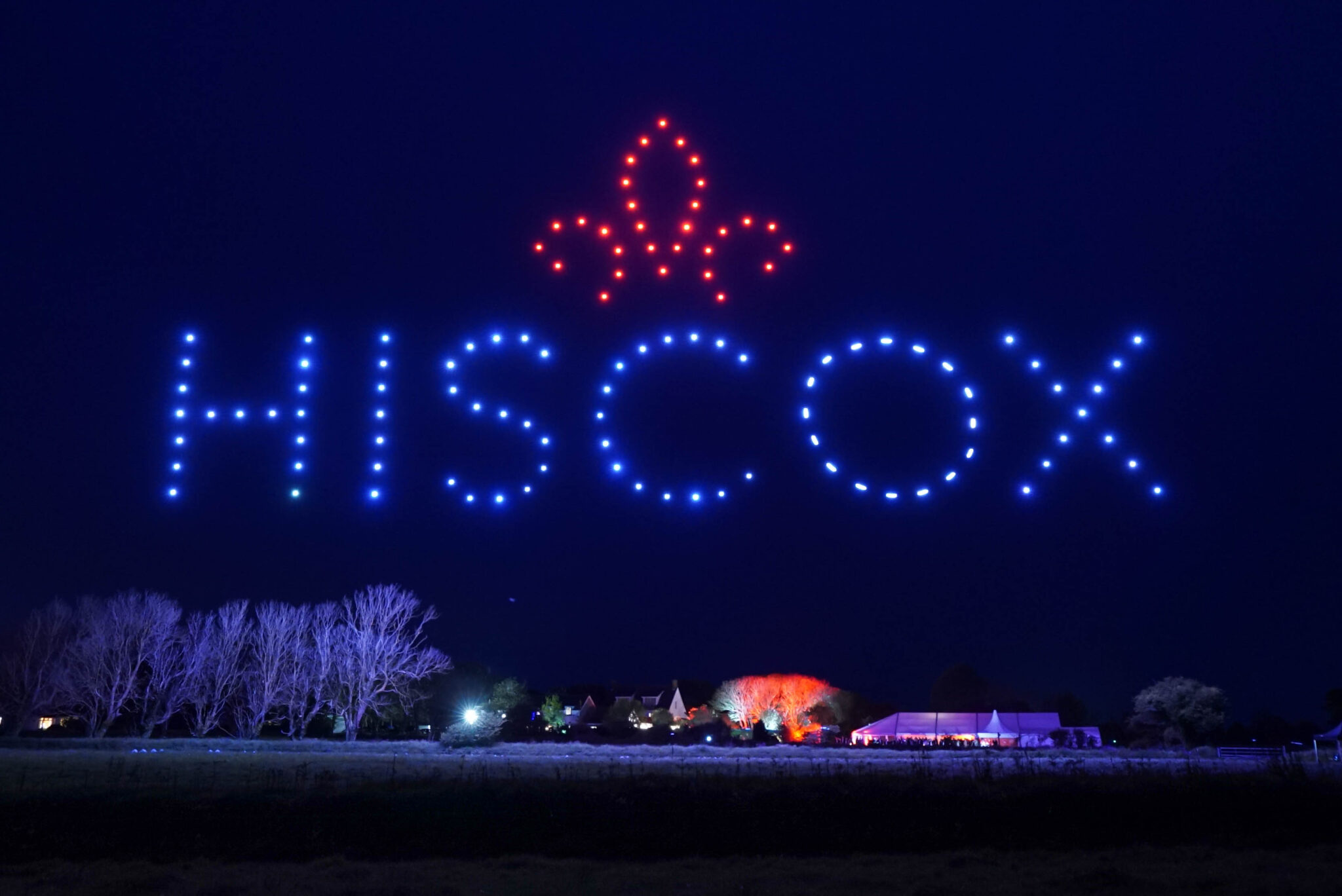 Corporate message and symbol formed by drones above an event venue