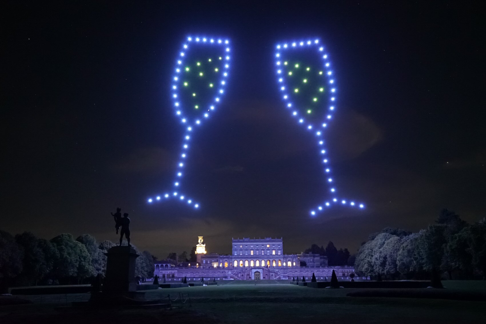 Champagne glasses formed by drones above a wedding venue